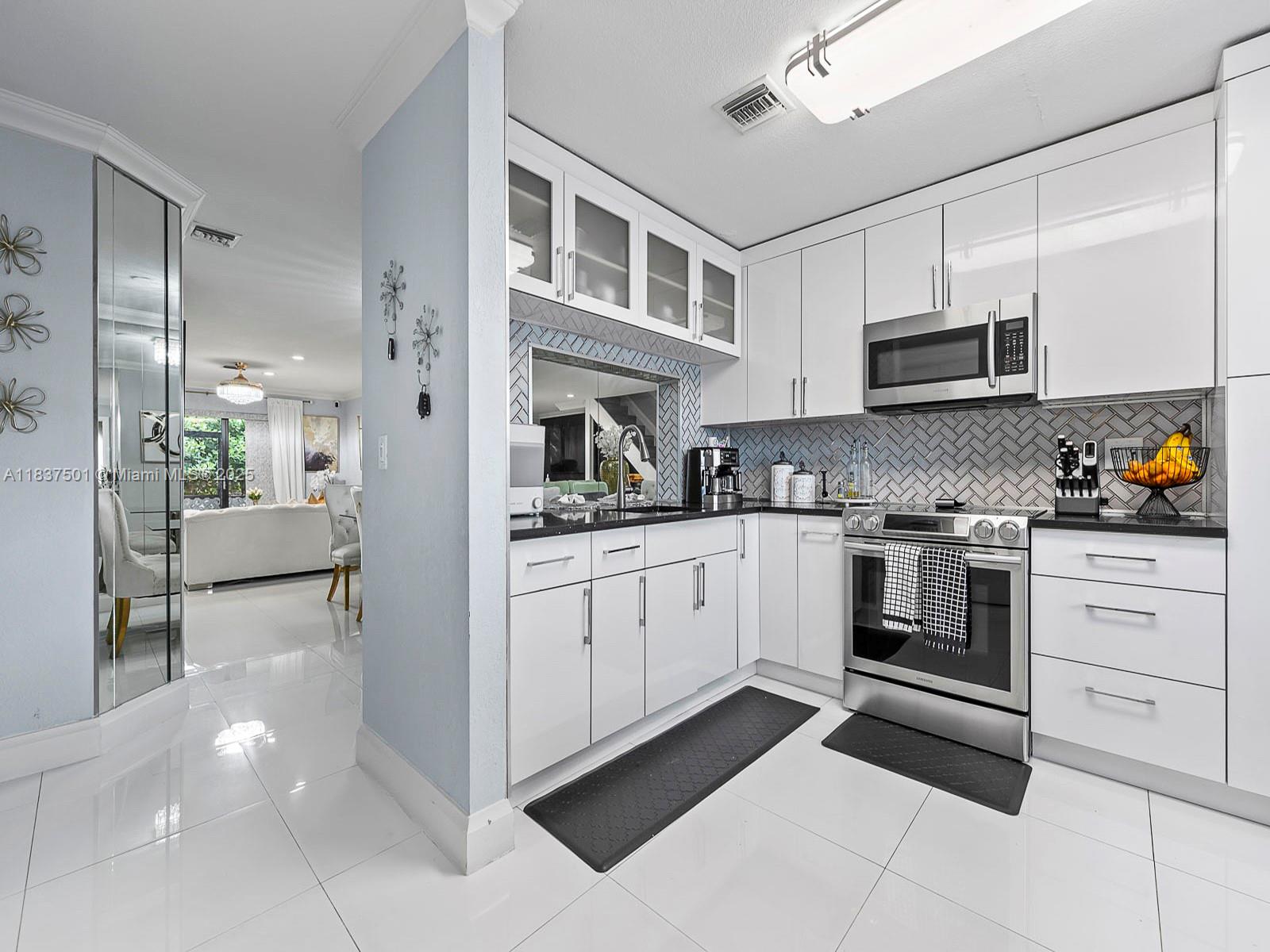 10942 West Sample Road, Unit E1 Coral Springs, FL 33065 - Photo 14 of 32 a kitchen with stainless steel appliances a stove a sink and a refrigerator