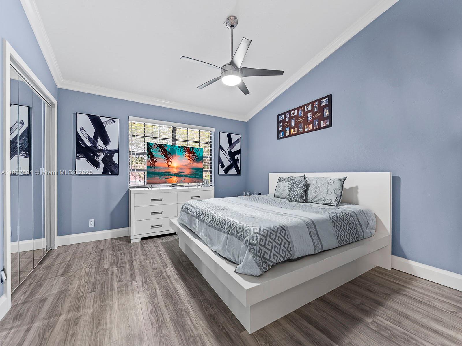 10942 West Sample Road, Unit E1 Coral Springs, FL 33065 - Photo 17 of 32 a living room with a bed and a flat screen tv