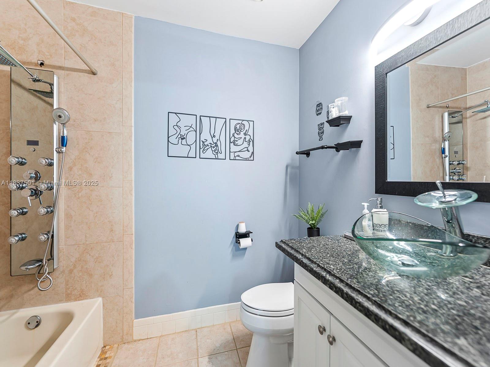10942 West Sample Road, Unit E1 Coral Springs, FL 33065 - Photo 20 of 32 a bathroom with a granite countertop sink a toilet and shower