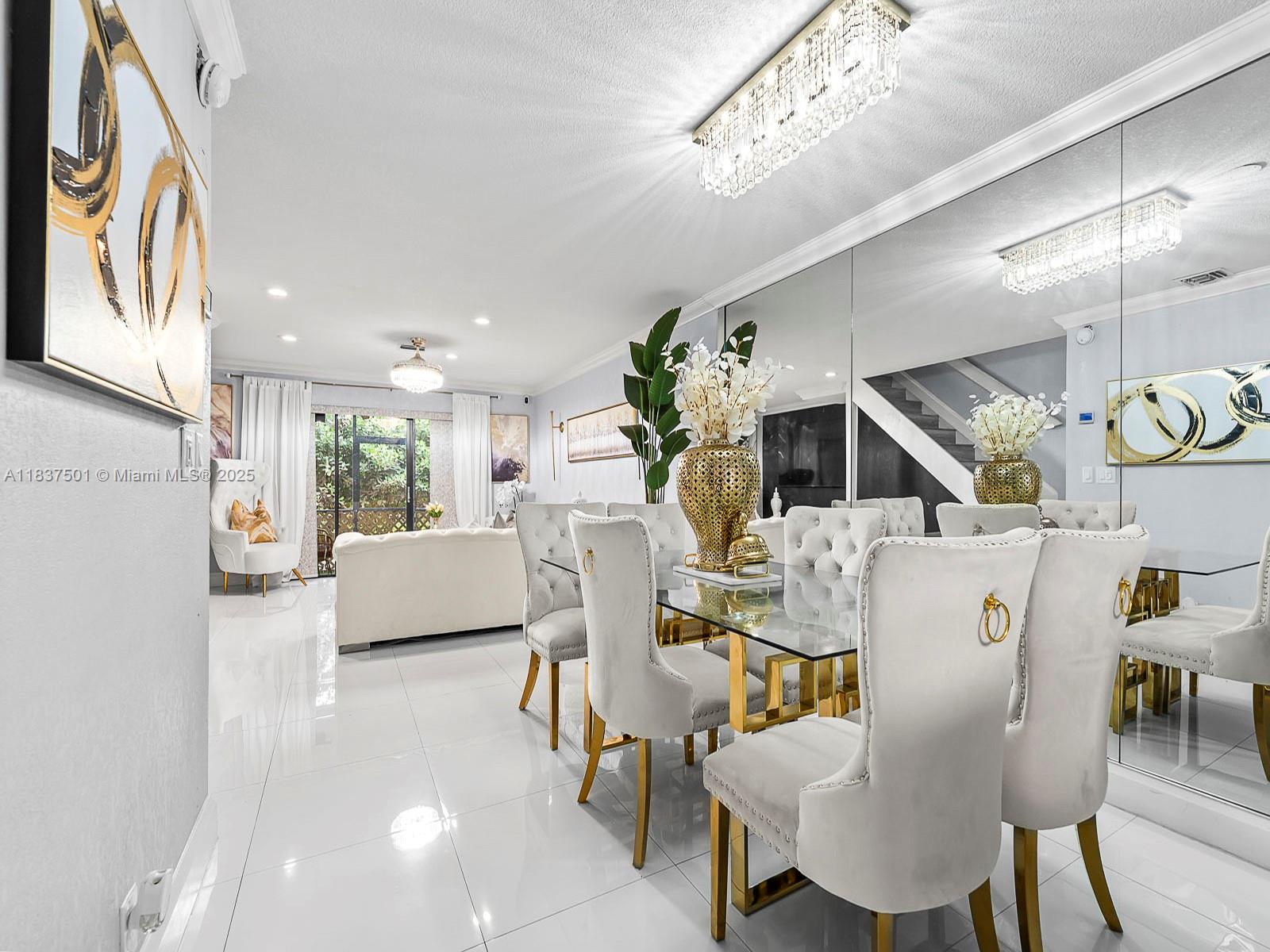 10942 West Sample Road, Unit E1 Coral Springs, FL 33065 - Photo 2 of 32 a living room with furniture a chandelier and a dining table with wooden floor