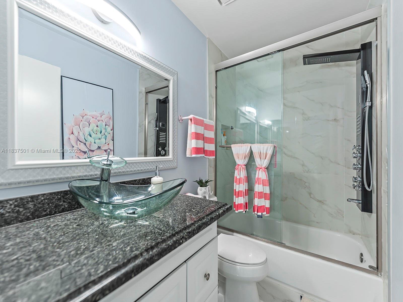 10942 West Sample Road, Unit E1 Coral Springs, FL 33065 - Photo 21 of 32 a bathroom with a granite countertop sink a toilet and shower