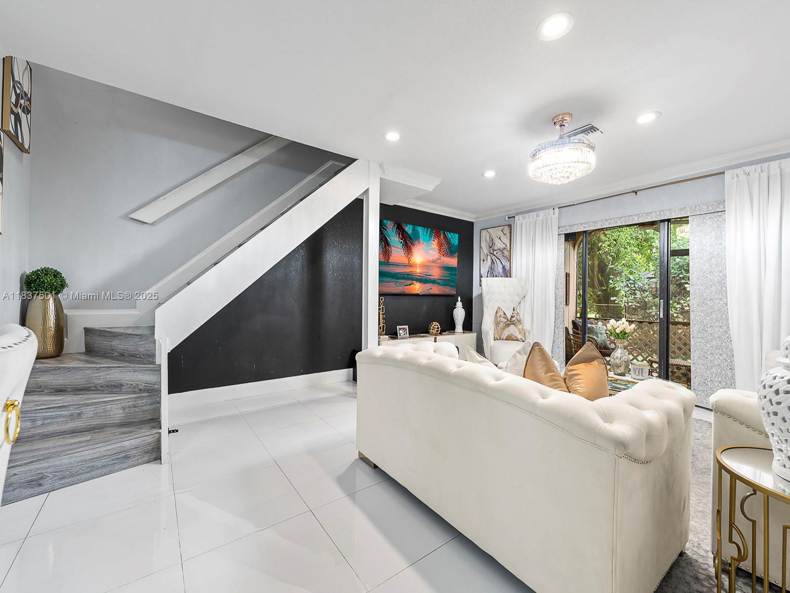 10942 West Sample Road, Unit E1 Coral Springs, FL 33065 - Photo 4 of 32 a living room with furniture and a flat screen tv
