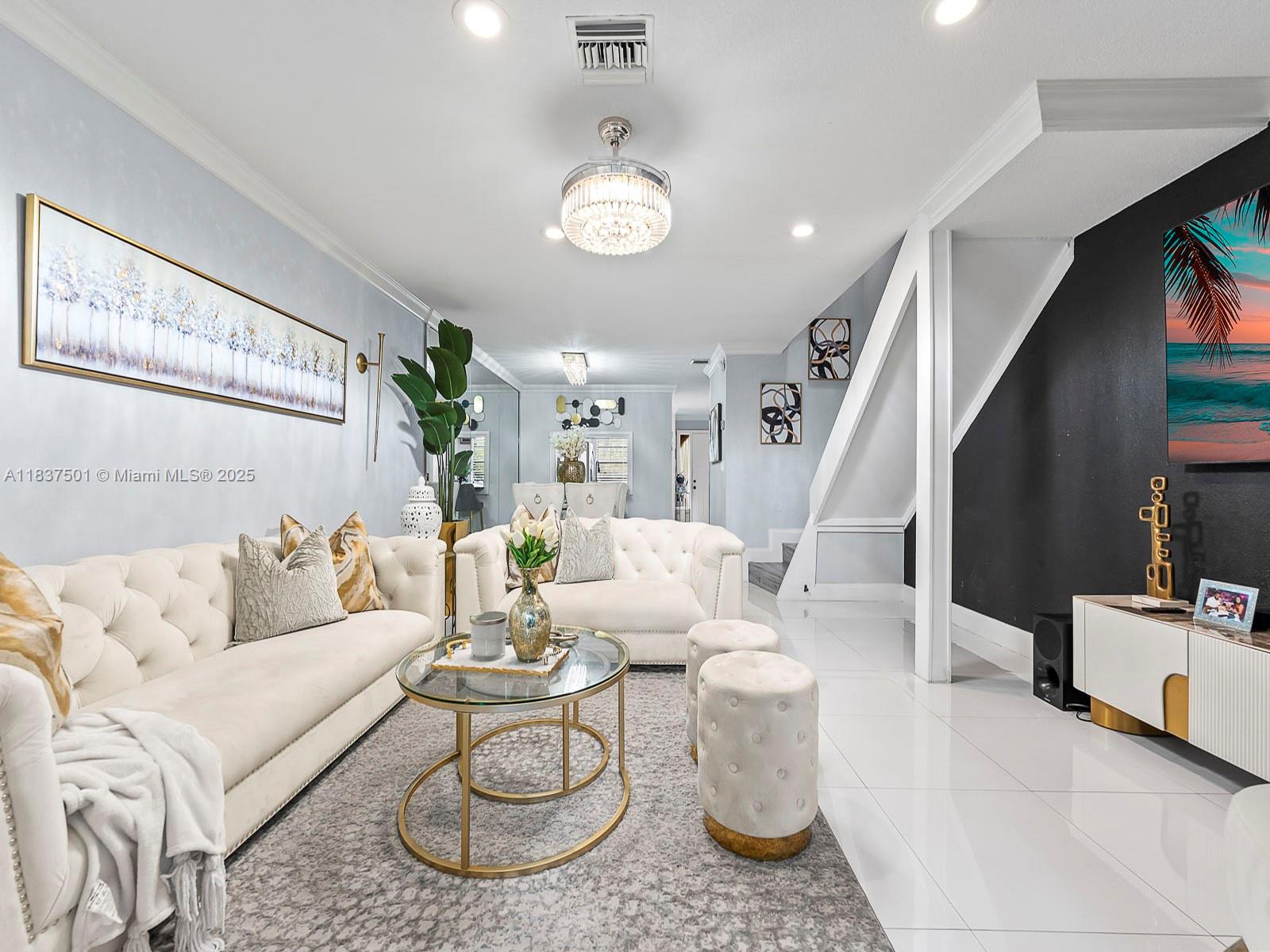 10942 West Sample Road, Unit E1 Coral Springs, FL 33065 - Photo 6 of 32 a living room with furniture and a chandelier