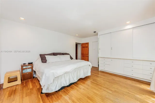 a spacious bedroom with a bed and a wooden floor