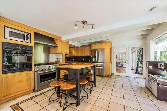 a kitchen with a sink a counter top space and stainless steel appliances