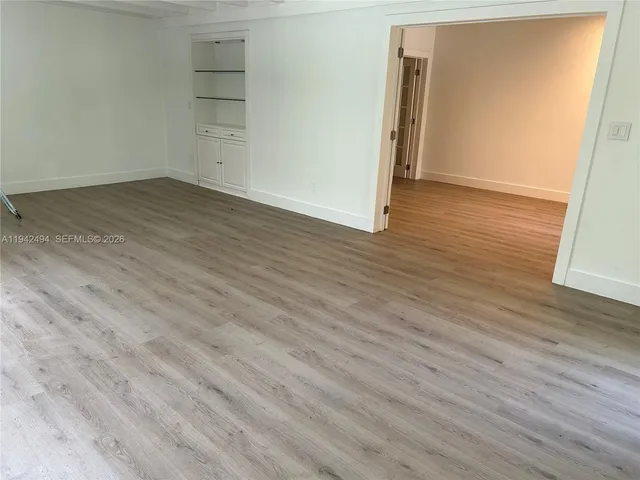 an empty room with wooden floor and closet