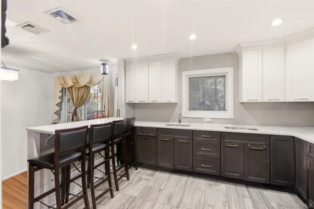 a kitchen with a sink a window and wooden cabinets