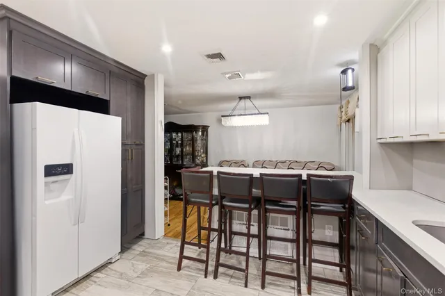 a kitchen with stainless steel appliances a table chairs and a refrigerator