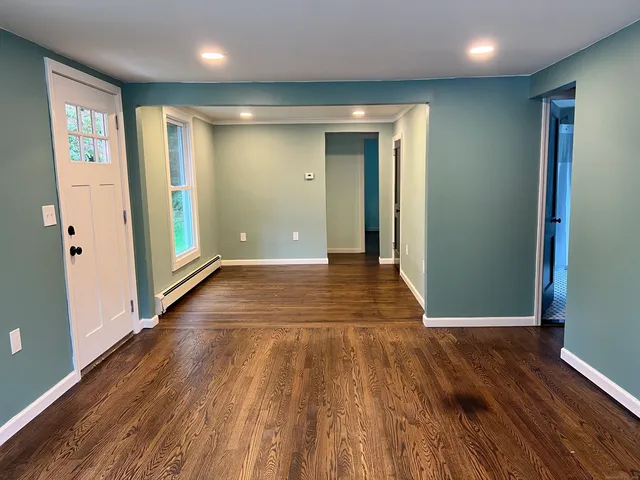an empty room with wooden floor and entrance