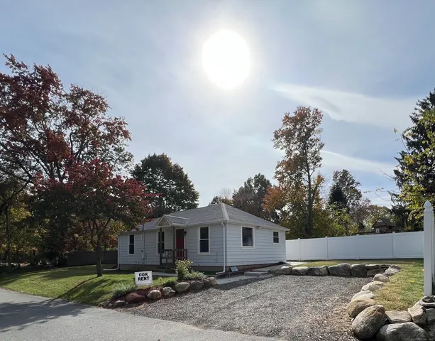 a front view of a house with a garden and trees