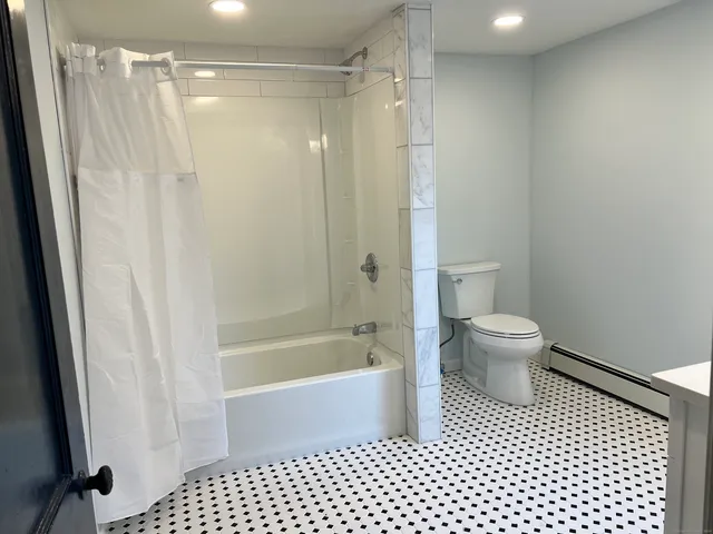 a bathroom with a shower a toilet and a shower