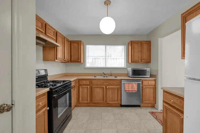 a kitchen with stainless steel appliances granite countertop a stove sink and cabinets