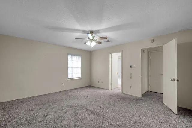 a view of a livingroom with a ceiling fan and window