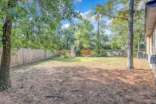 a view of backyard with tree and wooden fence