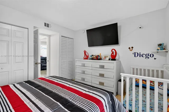 a bedroom with bed and a flat screen tv