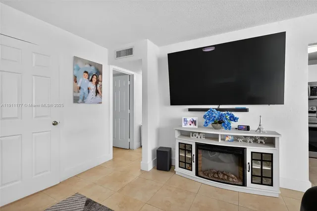 a living room with flat screen tv and a fireplace