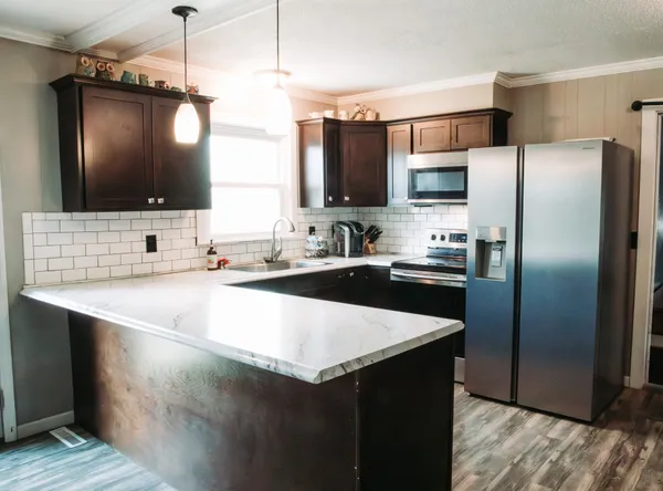 a kitchen with kitchen island a counter space a sink and refrigerator