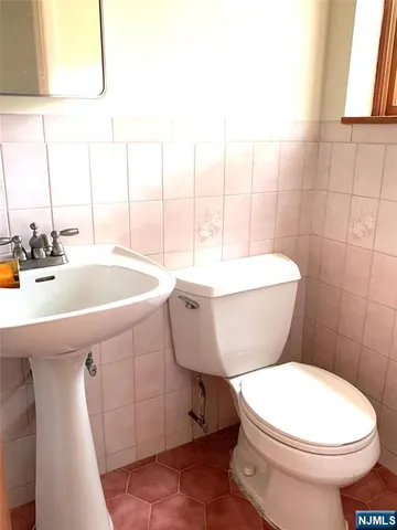 a bathroom with a sink a toilet and mirror