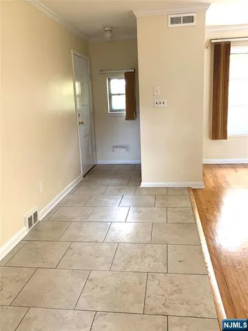 a view of a hallway with wooden floor and a bathroom