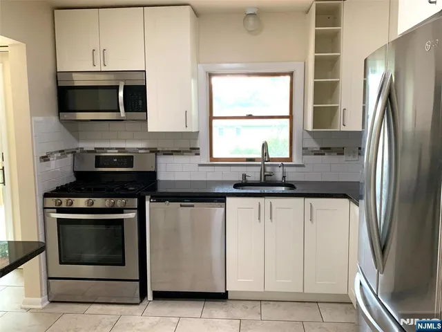 a kitchen with stainless steel appliances a stove microwave and sink