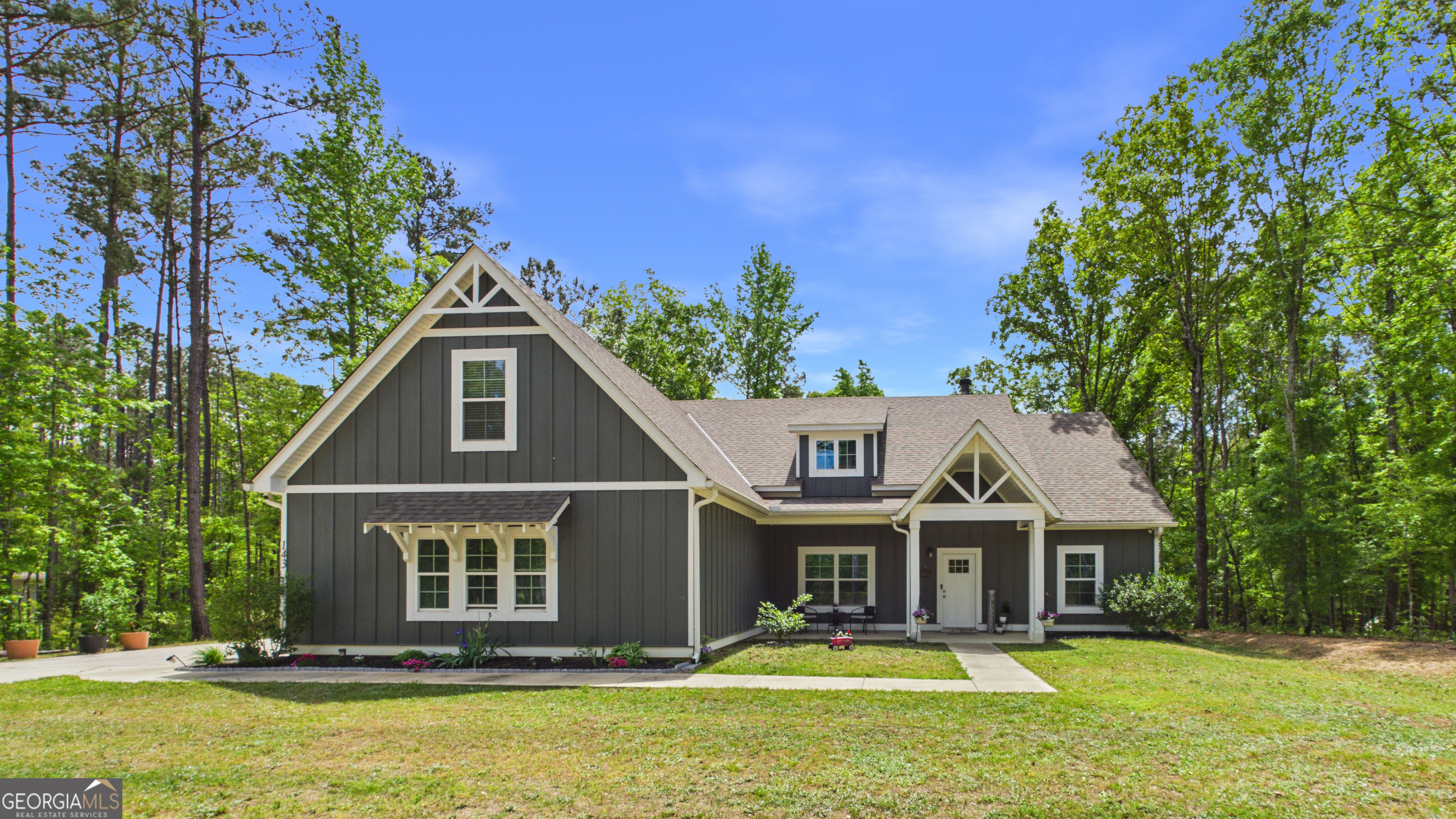 a front view of a house with a garden and trees