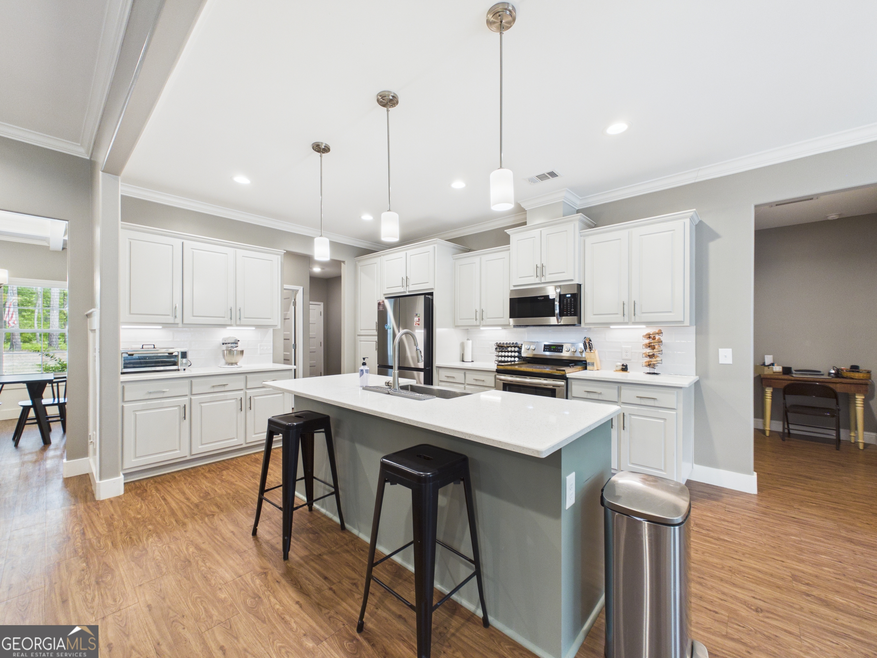 143 Terry Lane Fortson, GA 31808 - Photo 11 of 46 a kitchen with stainless steel appliances kitchen island a white table chairs and a refrigerator