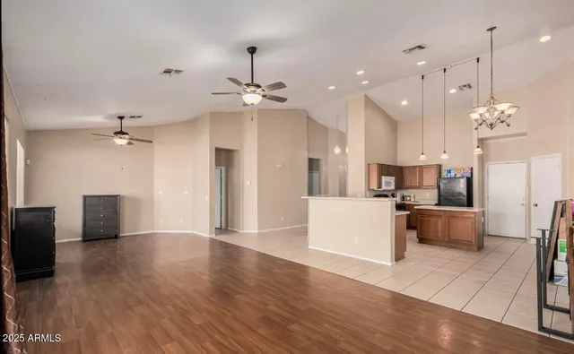 a view of a kitchen with a refrigerator a sink dishwasher a oven and a dining table with wooden floor