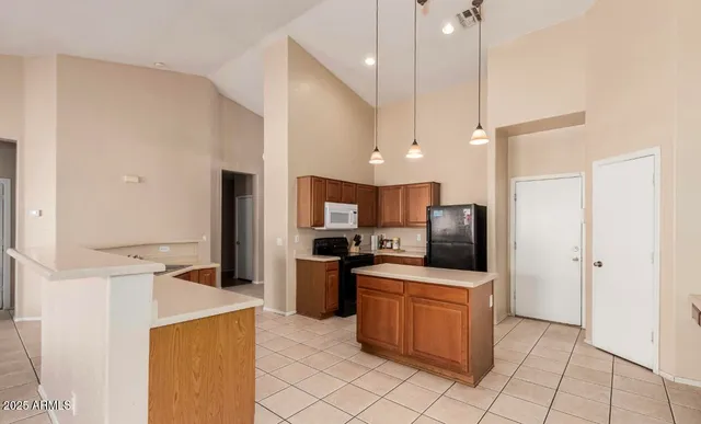 a kitchen with stainless steel appliances a stove a refrigerator a sink a oven with a dining table and chairs