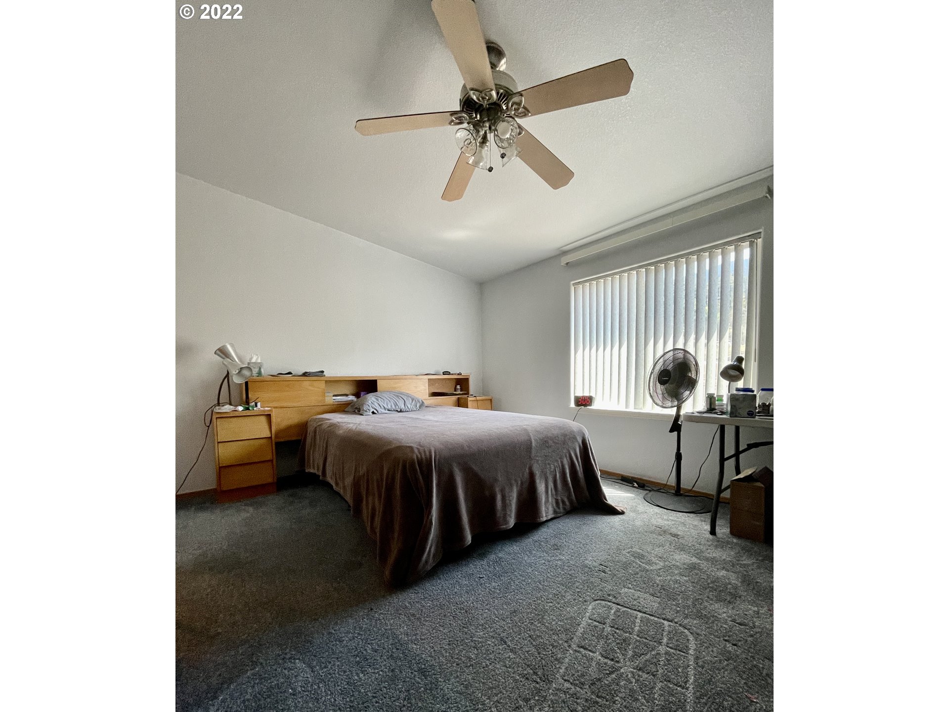 307 Evergreen Ridge Road Riddle, OR 97469 - Photo 12 of 29 a spacious bedroom with a bed and a chandelier
