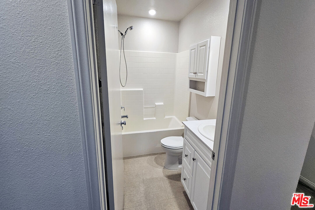 7245 Maple Road Van Nuys, CA 91405 - Photo 17 of 45 a bathroom with a granite countertop toilet a sink and a mirror