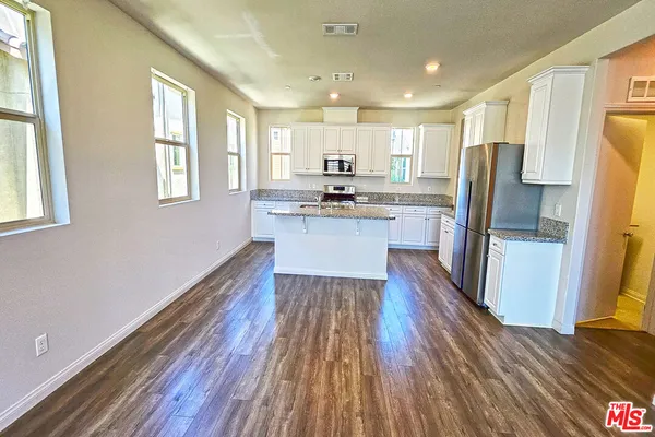 a kitchen with wooden floors and refrigerator