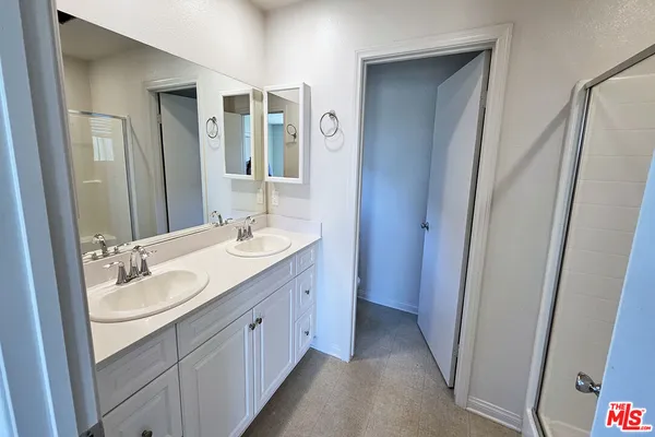a spacious bathroom with a double vanity sink and mirror