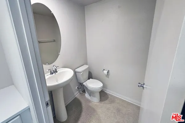 a white toilet sitting next to a small sink