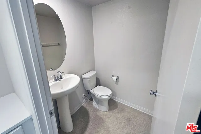 a white toilet sitting next to a small sink