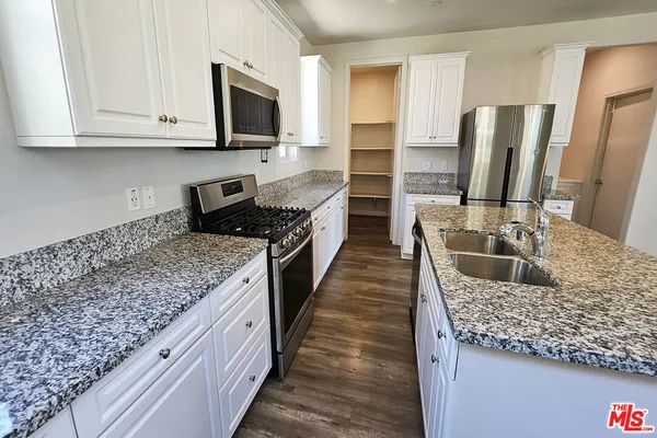 a kitchen with stainless steel appliances kitchen island granite countertop a refrigerator stove and oven