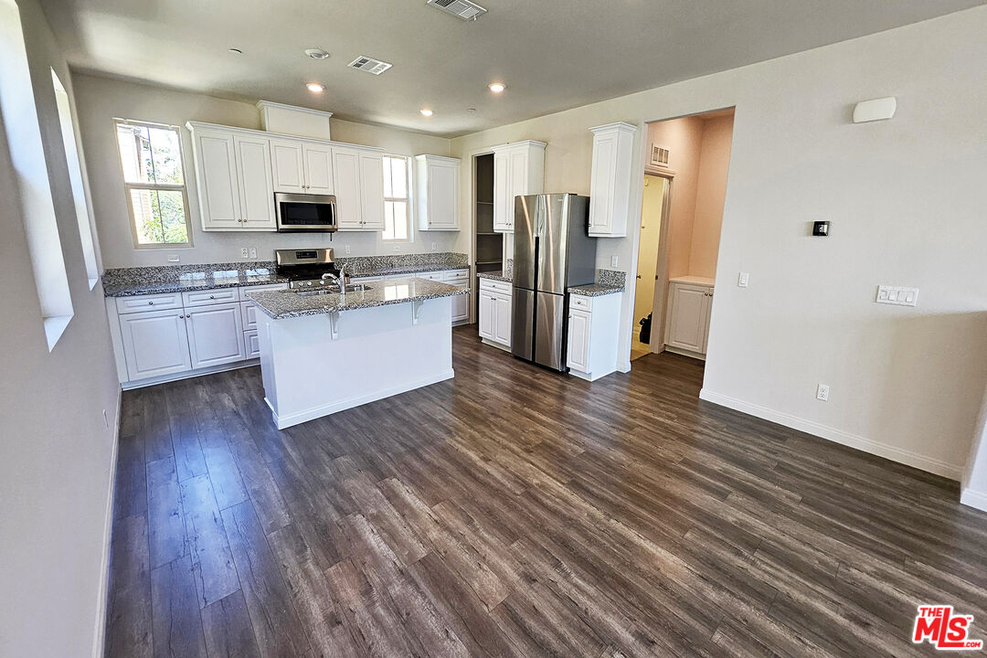 7245 Maple Road Van Nuys, CA 91405 - Photo 32 of 45 a kitchen with stainless steel appliances a refrigerator and wooden floor