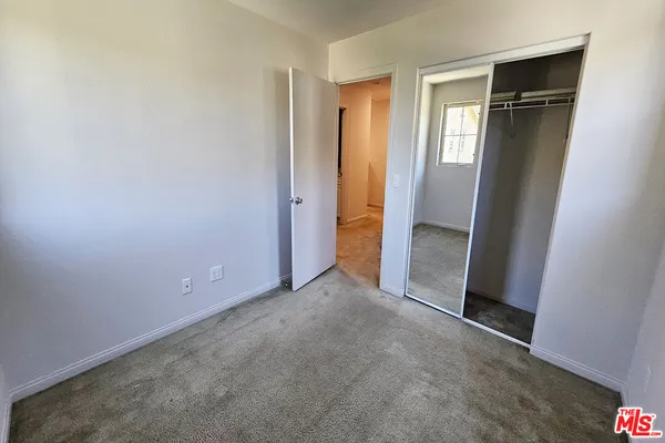 an empty room with closet and mirror