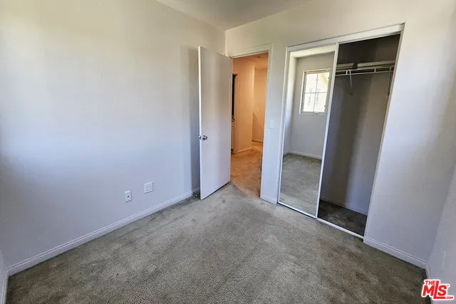 an empty room with closet and mirror