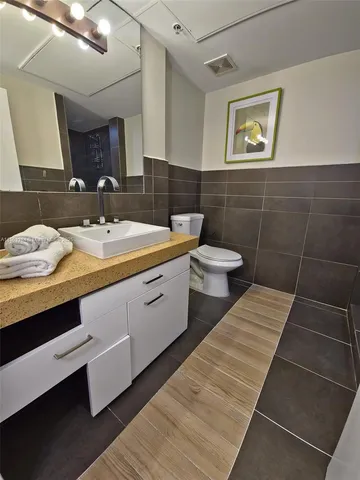 a bathroom with a double vanity sink toilet and mirror