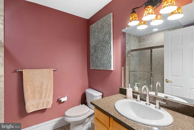 a bathroom with a sink a toilet a mirror and vanity