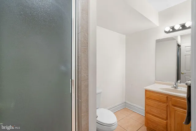 a bathroom with a sink a toilet a mirror and shower