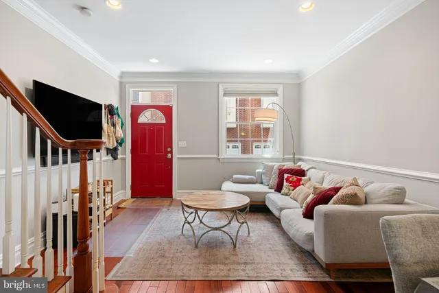 a living room with furniture a flat screen tv and a window