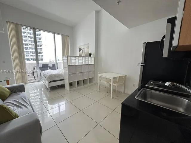 a room with furniture a flat screen tv and a window