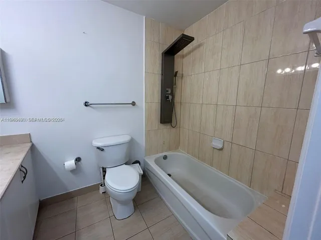 a white toilet sitting next to a bath tub