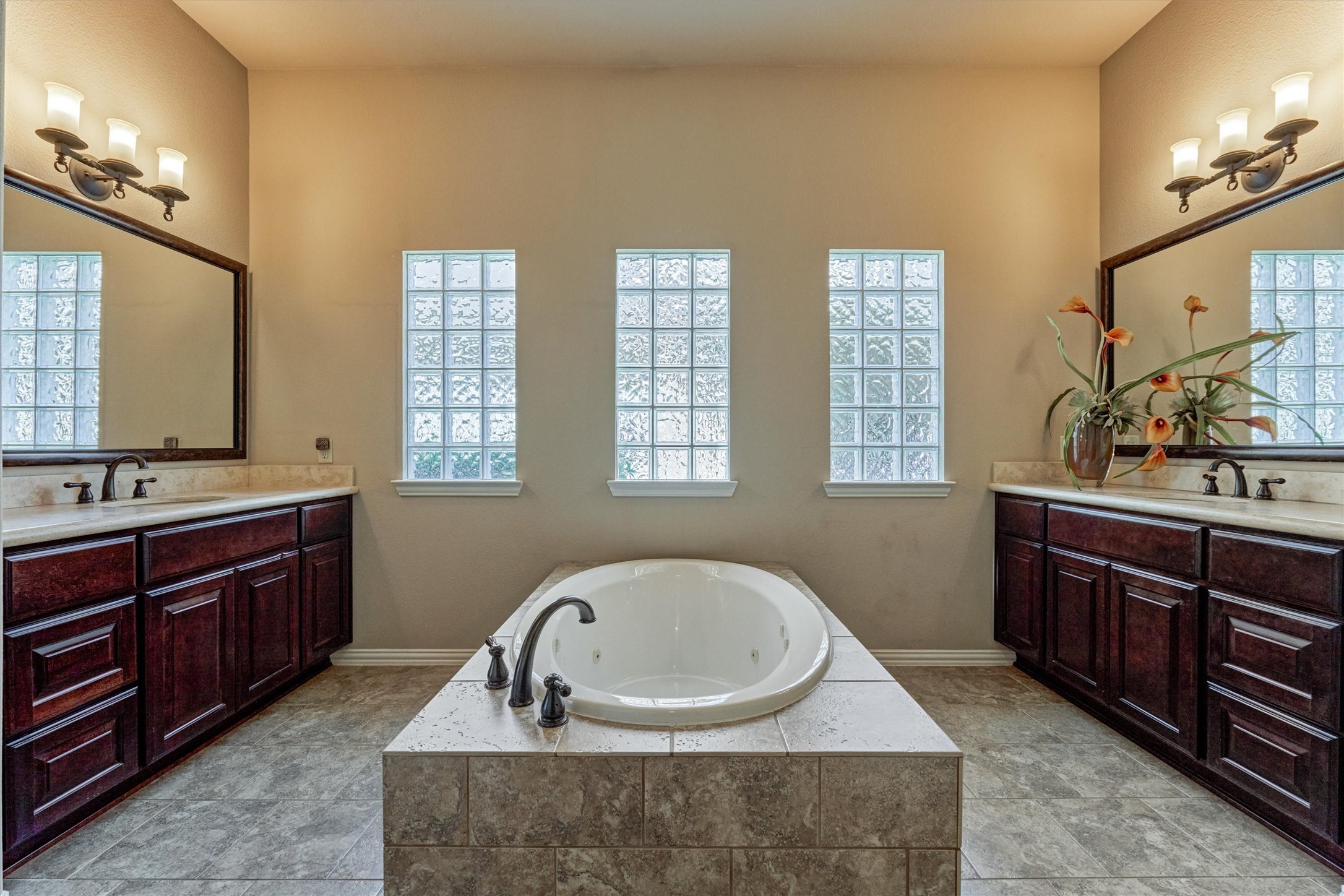 82 East Crystal Canyon Circle The Woodlands, TX 77389 - Photo 24 of 50 The spa-like primary bathroom is anchored by a relaxing jetted tub with a gorgeous tile surround and complemented by separate dual vanities.