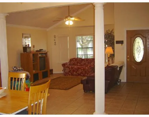 a living room with furniture a chandelier and a mirror