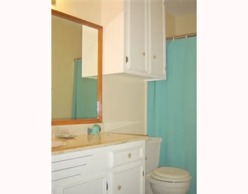 a bathroom with a granite countertop toilet sink and mirror