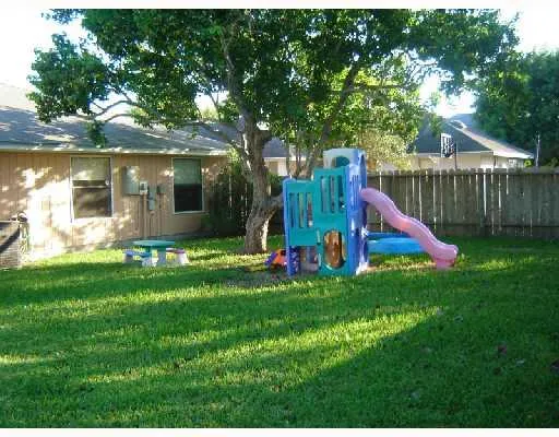 a view of a house with a backyard and a tree