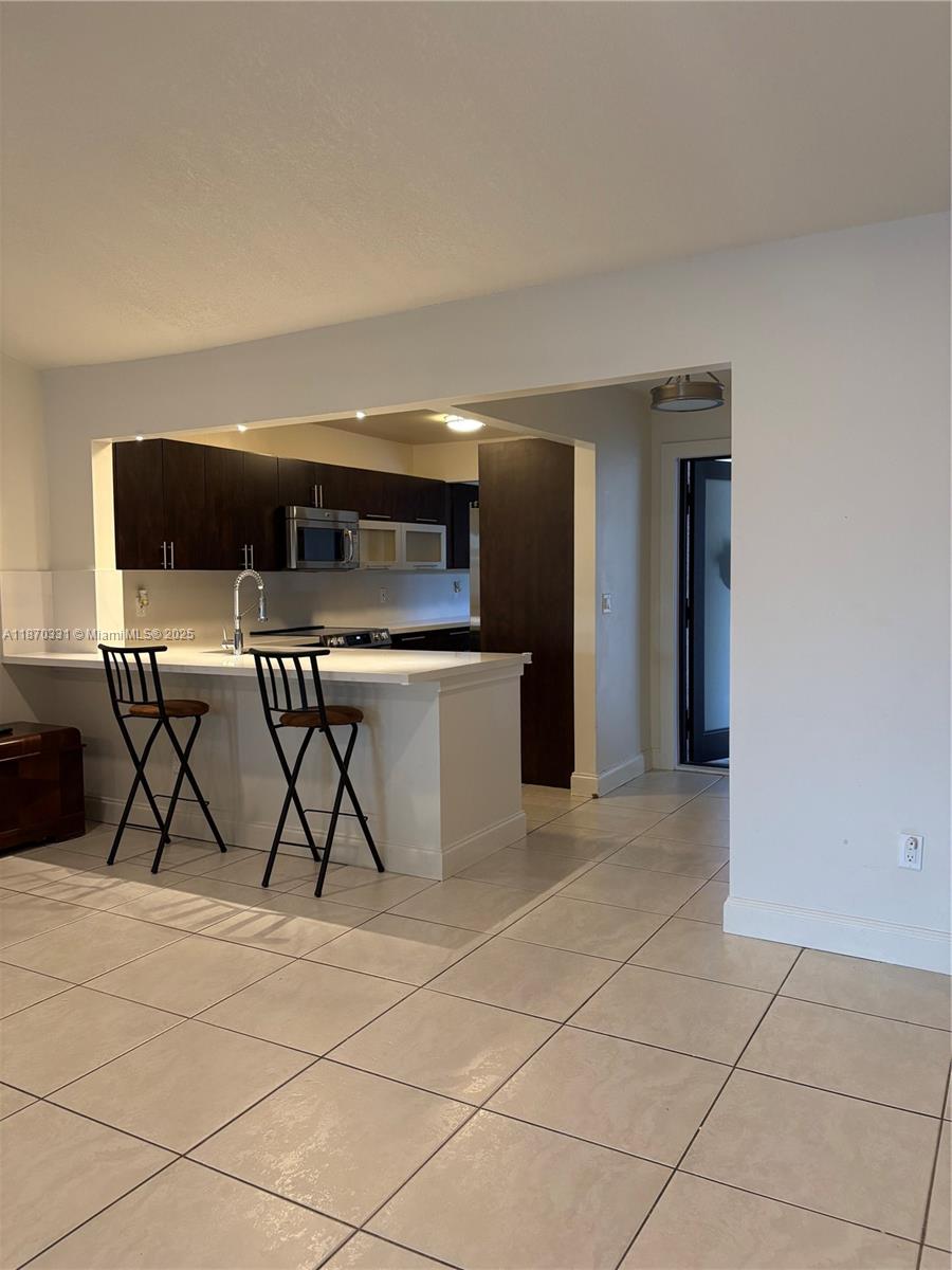 11527 Southwest 84th Lane Miami, FL 33173 - Photo 11 of 17 a kitchen with stainless steel appliances granite countertop a stove a sink and a refrigerator