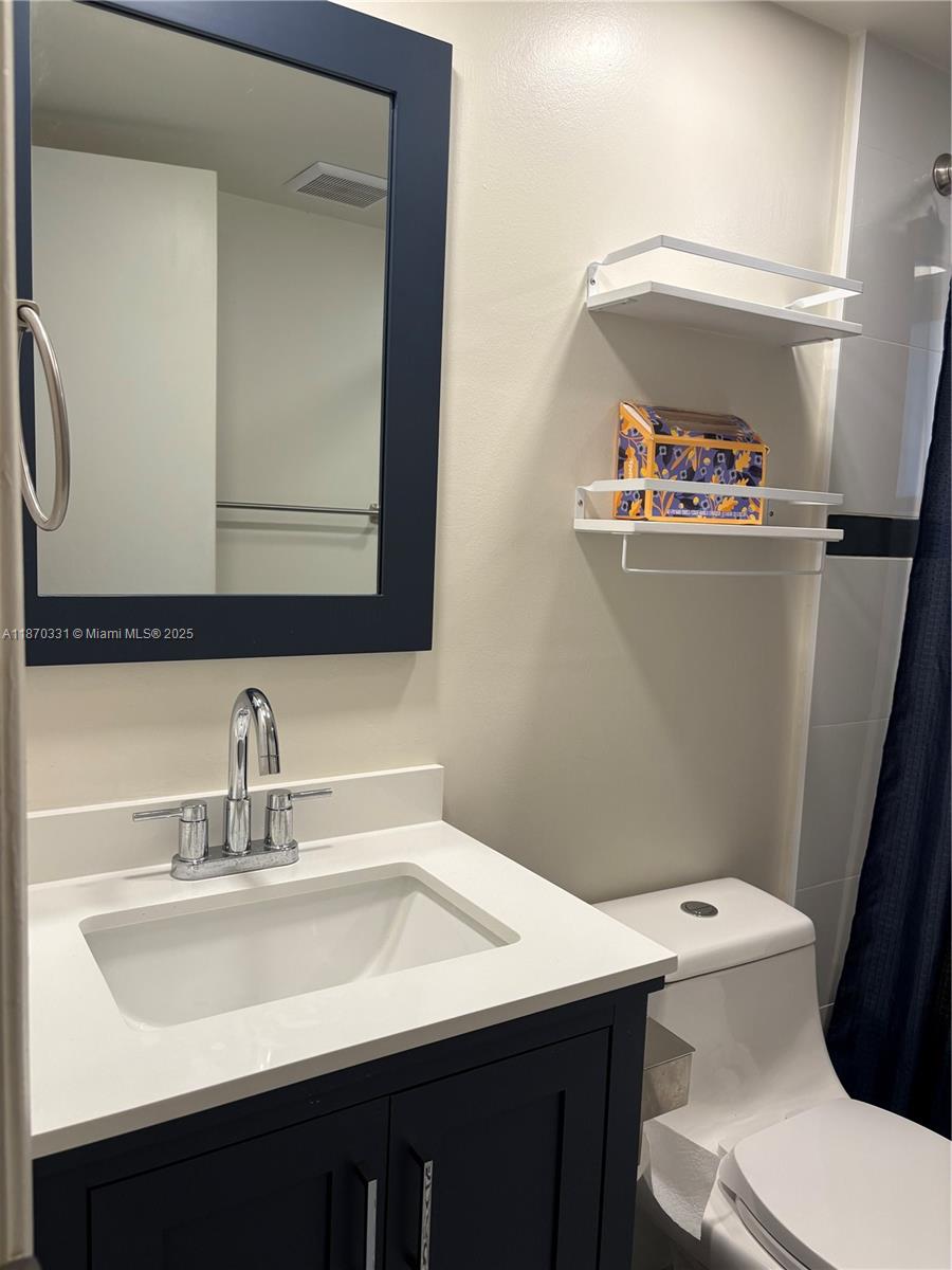 11527 Southwest 84th Lane Miami, FL 33173 - Photo 9 of 17 a bathroom with a sink a toilet and a mirror